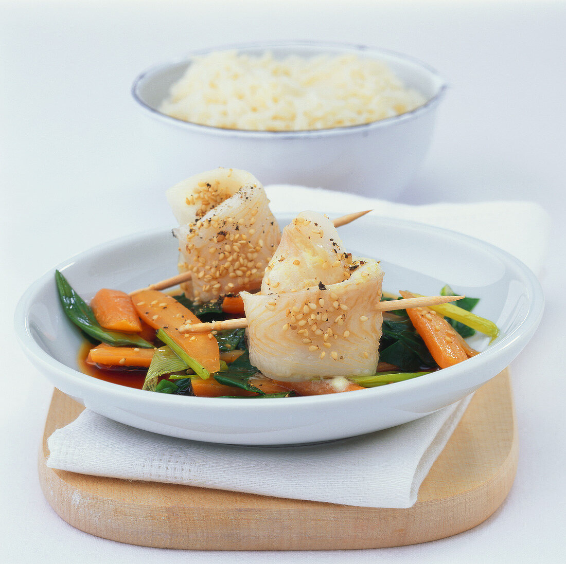 Steamed fish rolls with wasabi on a bed of vegetables