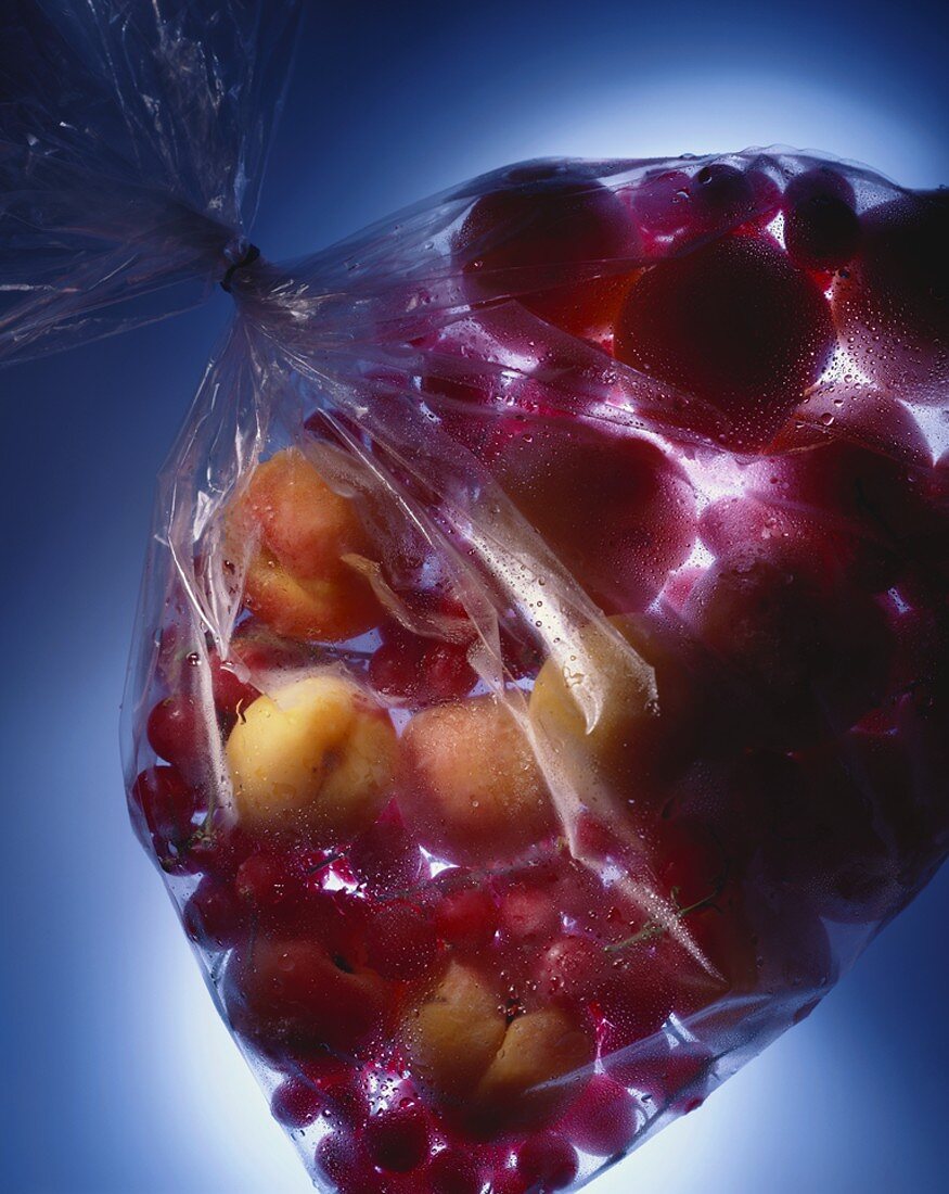 Apricots and redcurrants in plastic bag