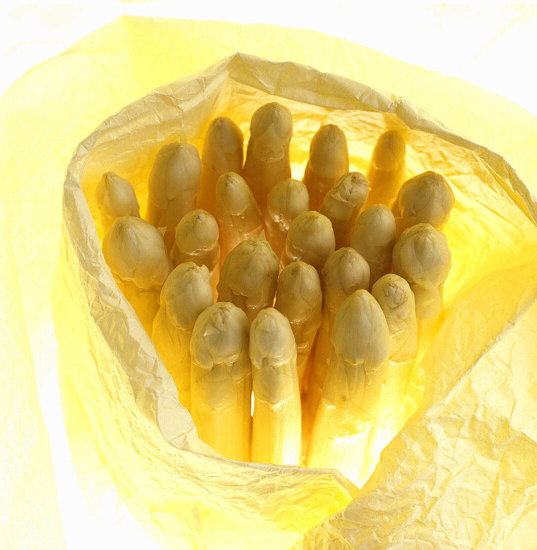 White asparagus spears wrapped in yellow paper