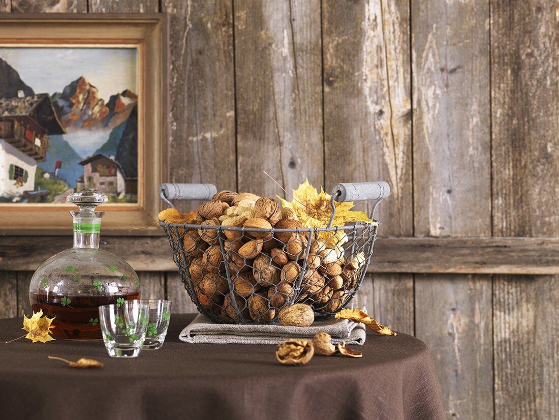 A basket full of nuts with a bottle of nut brandy