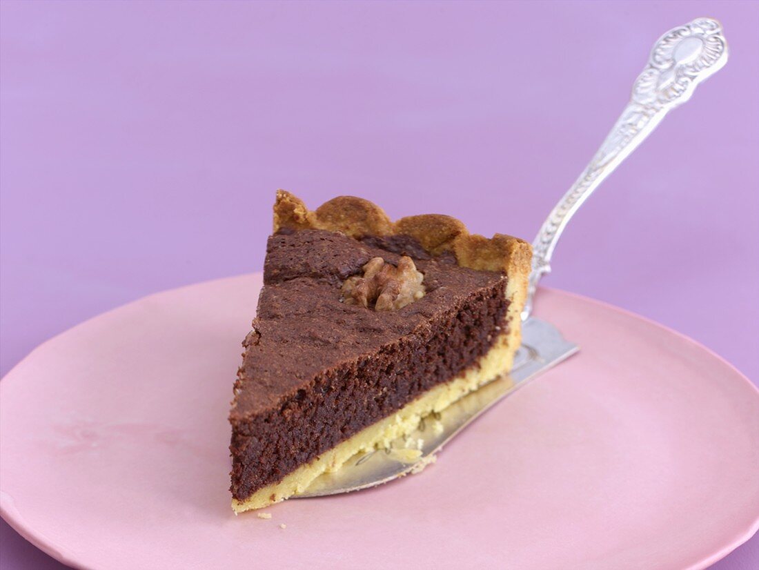 A piece of chocolate nut tart on a cake slice