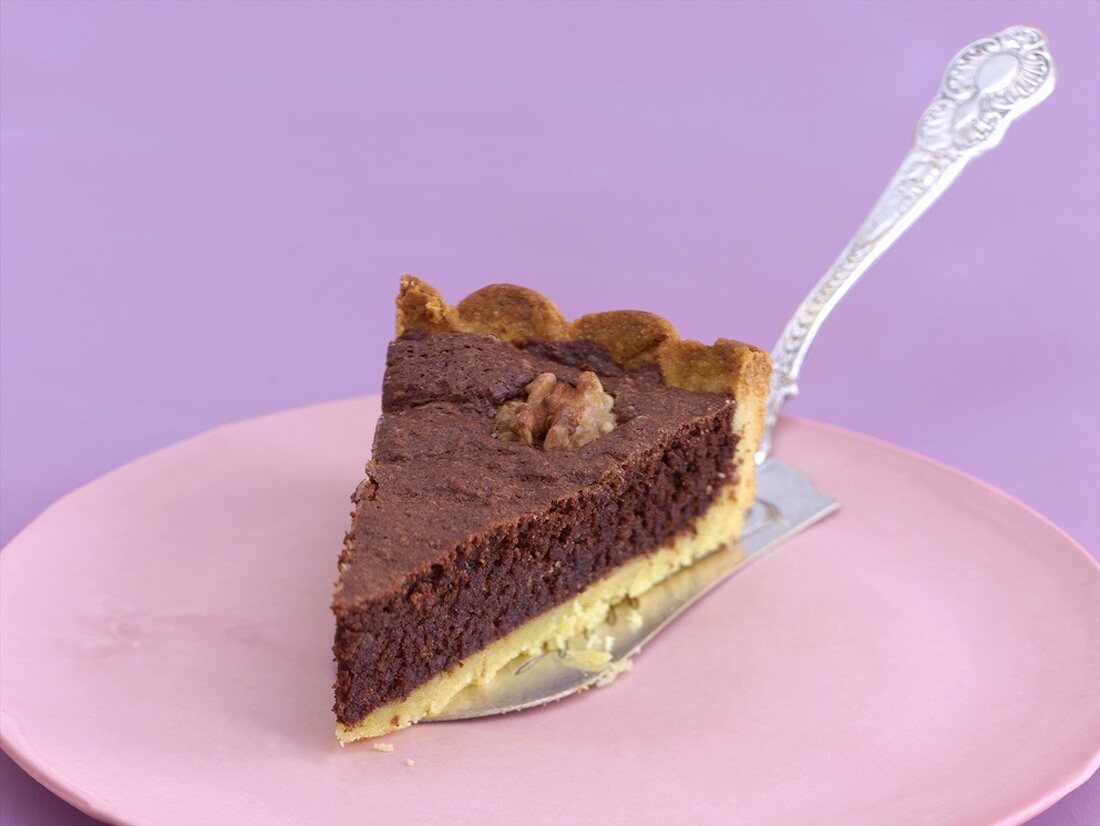 Ein Stück Schokoladen-Nuss-Tarte auf Kuchenheber