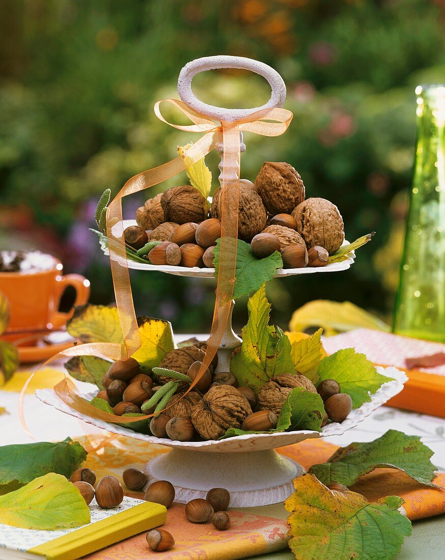 Nuts and autumn leaves on tiered stand