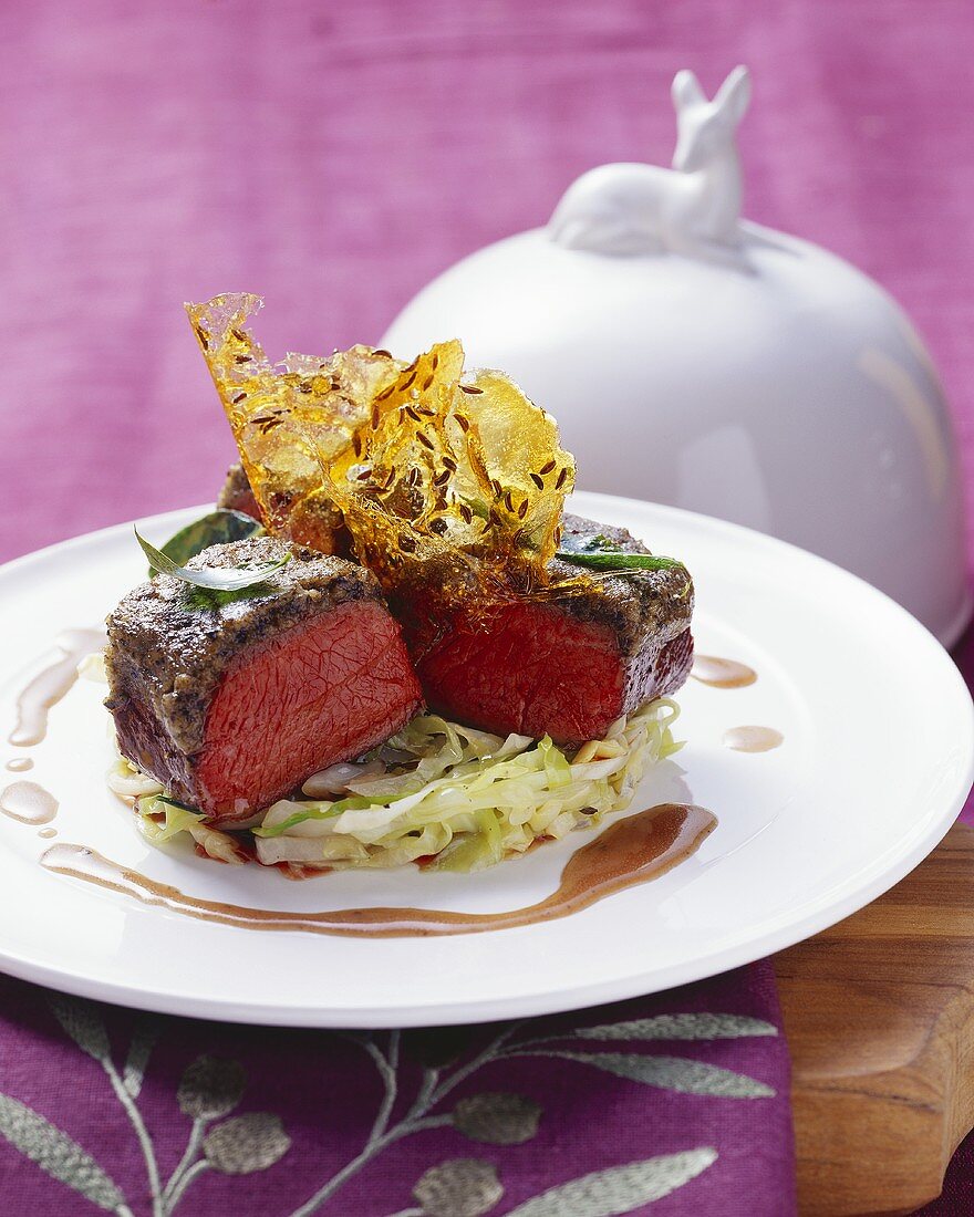 Loin of venison with olive crust and brittle on cabbage