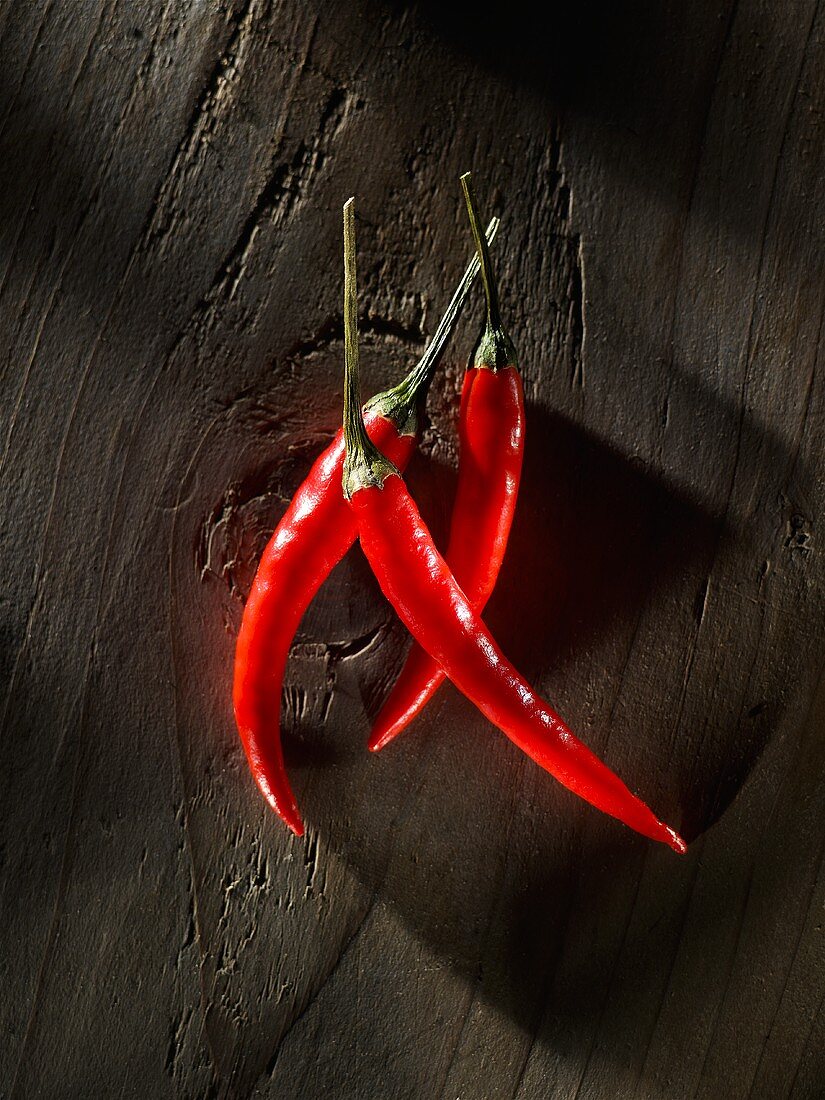 Three chillies on wood