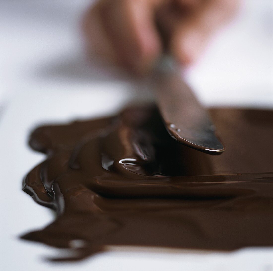 Flüssige Schokolade auf Arbeitsfläche streichen