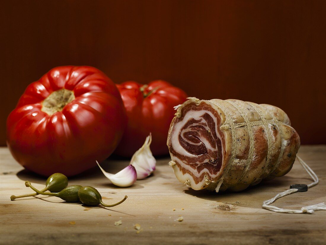 Italienisches Stillleben: Tomaten, Kapern, Knoblauch & Coppa