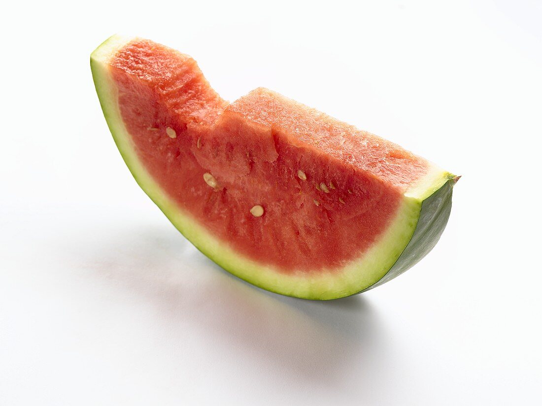 A slice of watermelon with a bite taken