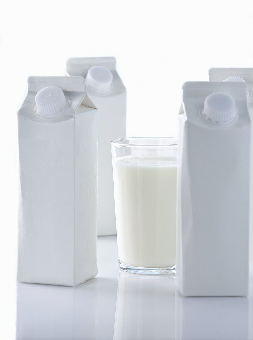 Glass of milk with milk cartons