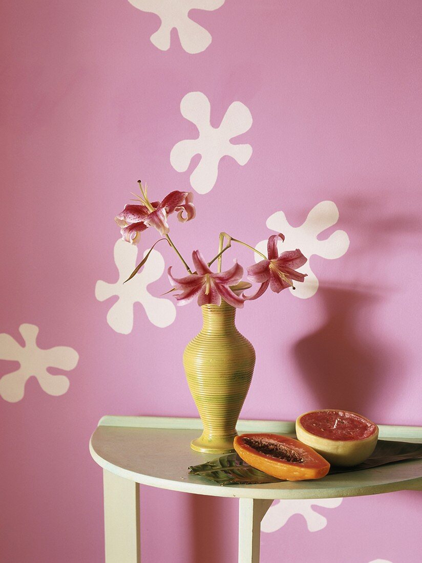 Exotic flowers and fruit on small table