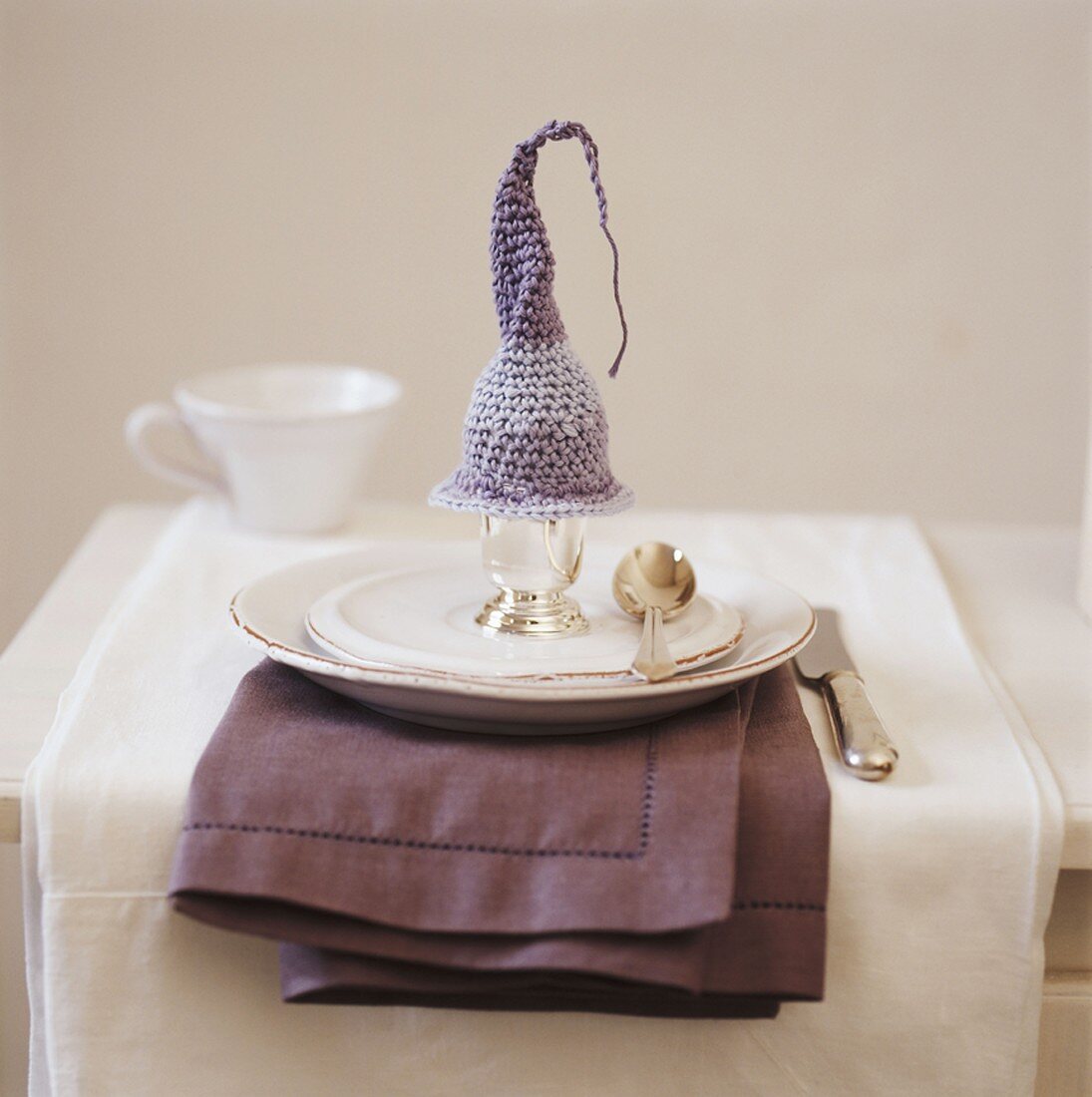 Place setting with boiled egg under a crocheted egg cosy