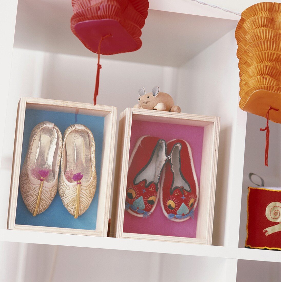 Lanterns hanging near shelving displaying Chinese shoes