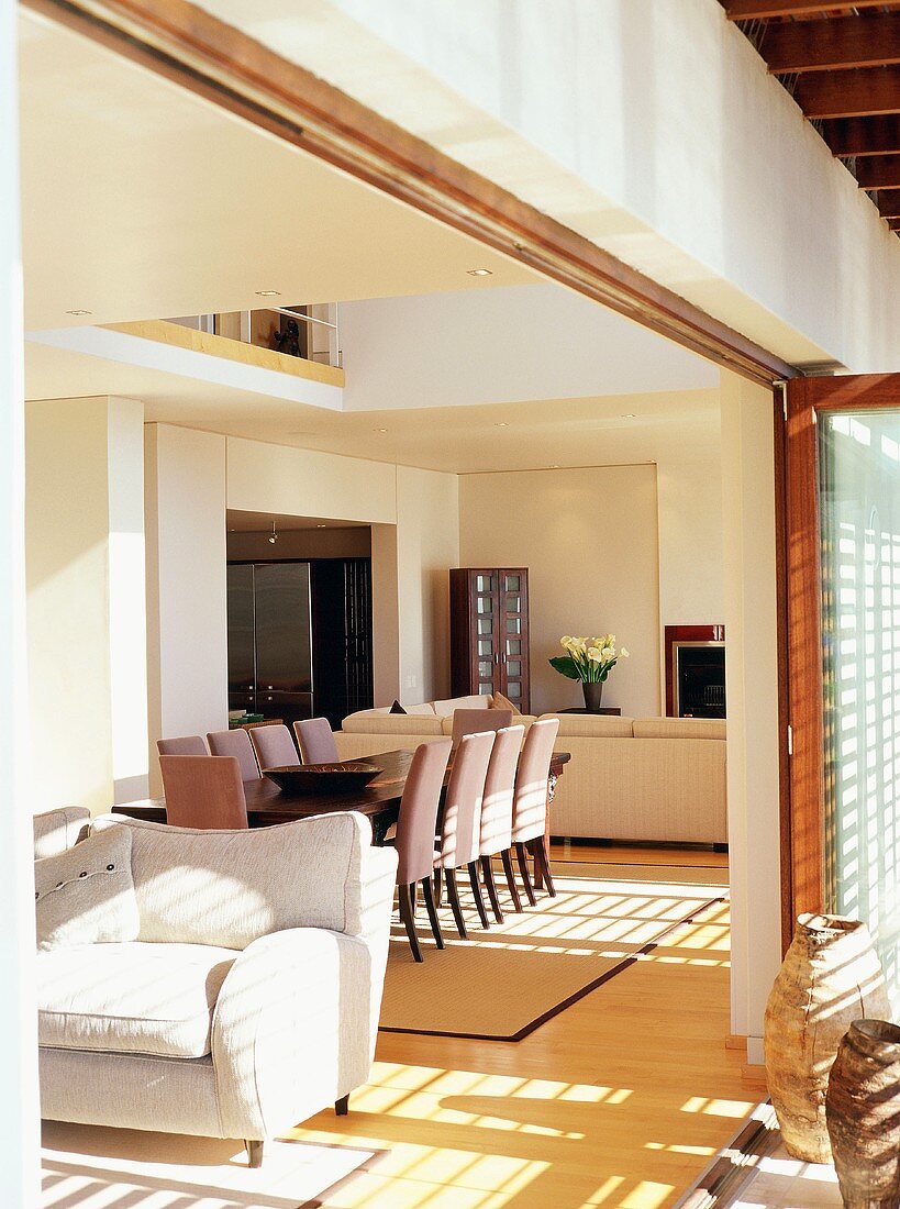 View through open terrace door of dining area and doorway to kitchen in open-plan interior