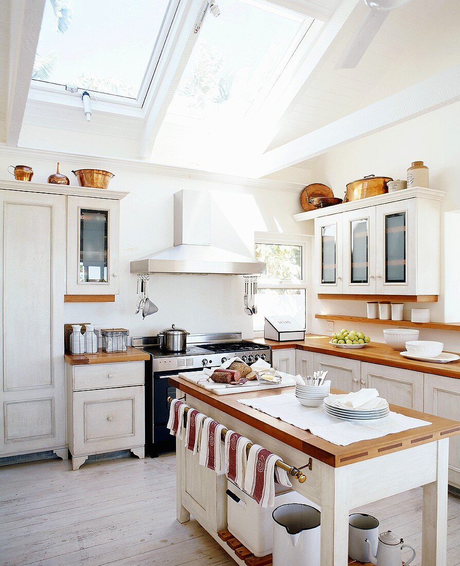 White, nostalgic, country-house kitchen with large skylights in sloping ceiling