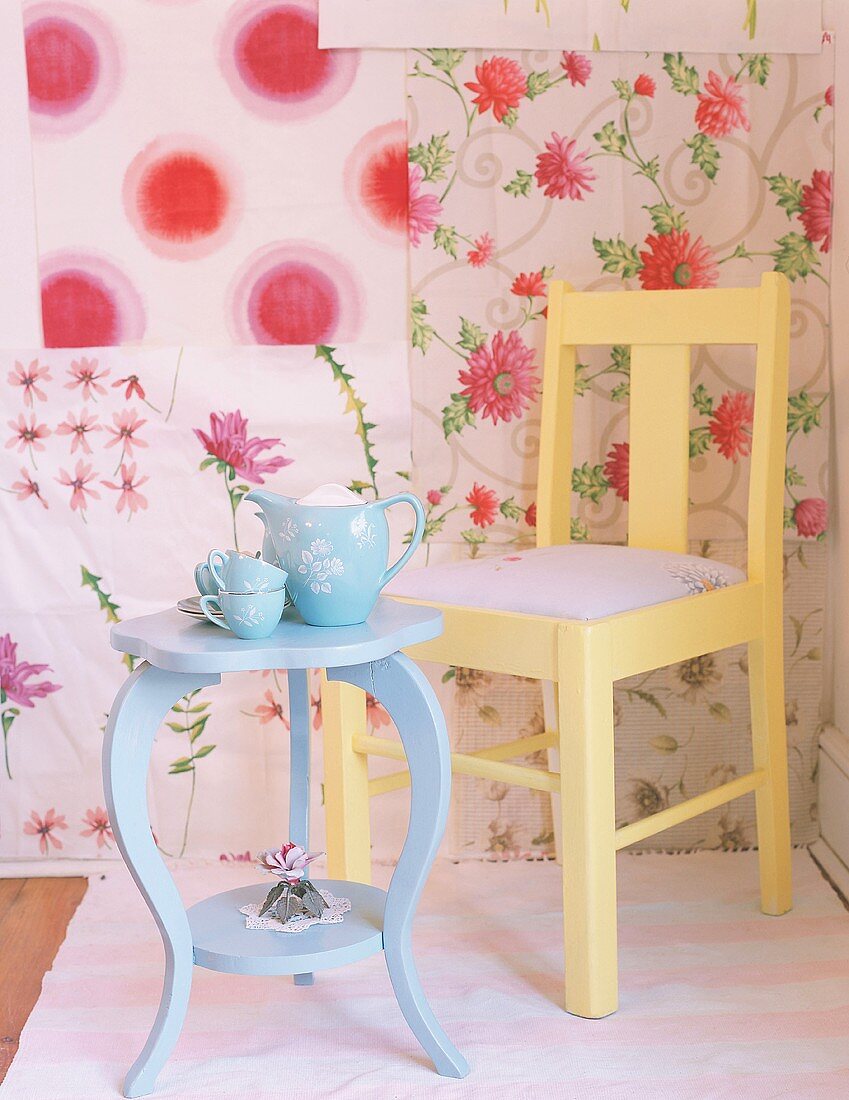 Chair and table in front of floral wallpaper