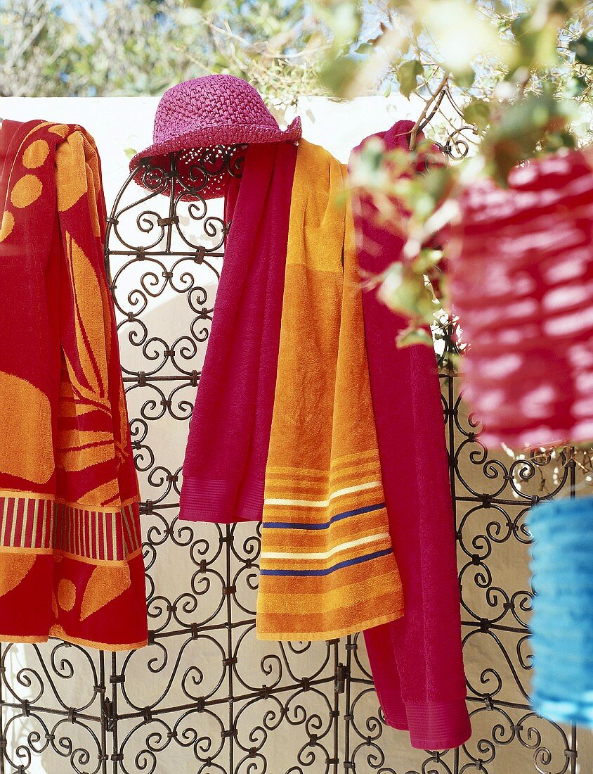 Hat and towels hanging on metal screen