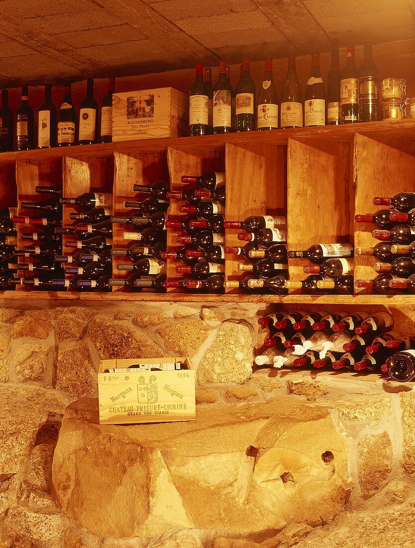 Ausschnitt eines privaten Weinkellers mit Steinwand und Holzregalen