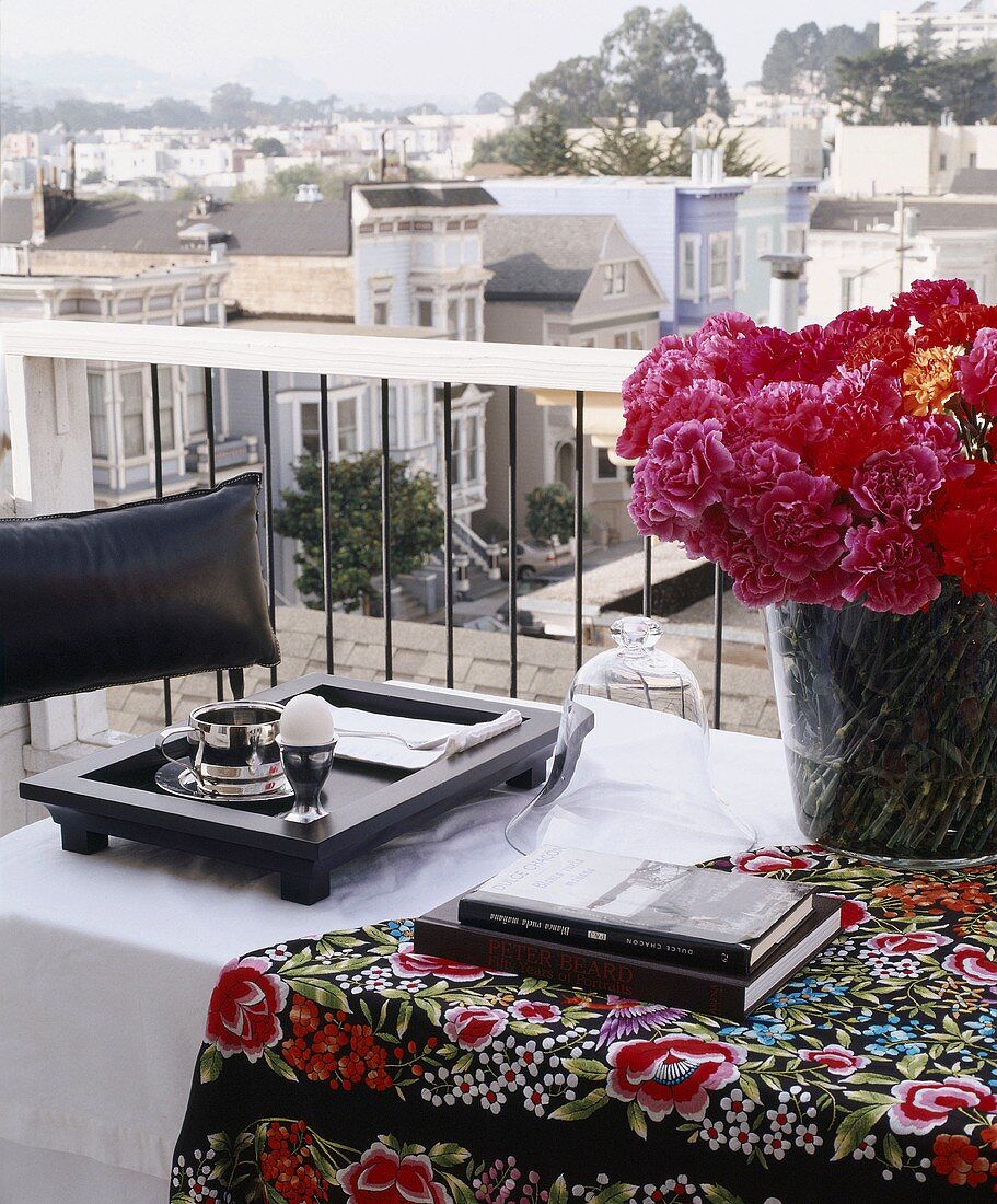 Flowers, books & breakfast tray on balcony table