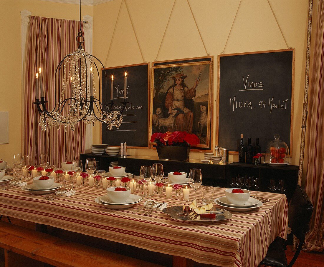 Festively set table with red carnations and apples