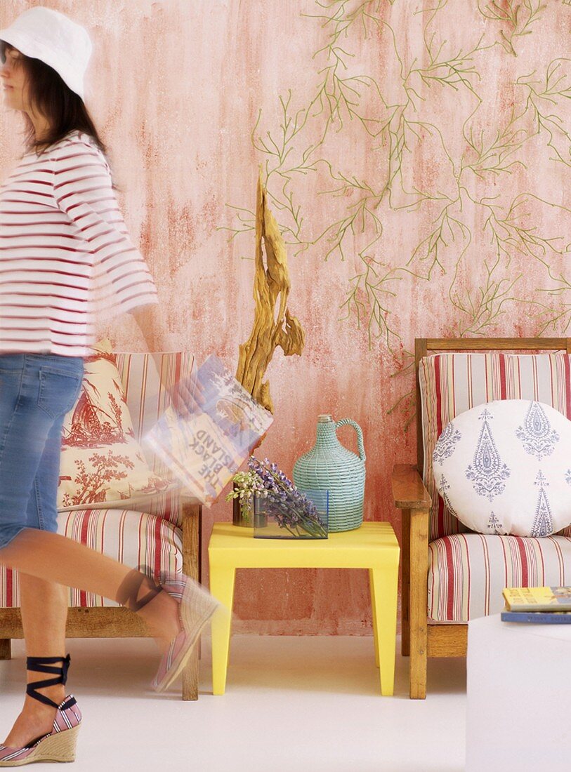 Woman wearing hat walking past chairs