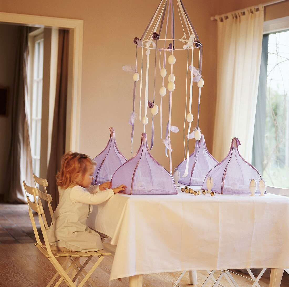 A girl at a table laid for Easter