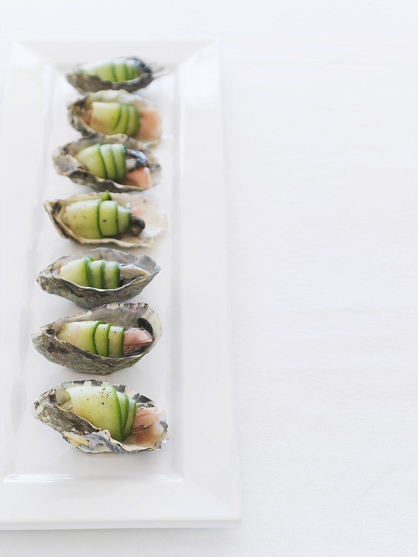 Oysters wrapped in cucumber on a long platter