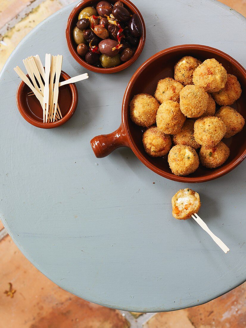 Two tapas: stuffed rice balls and marinated olives