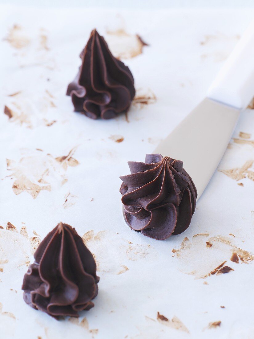 Three chocolate truffles piped using a star nozzle