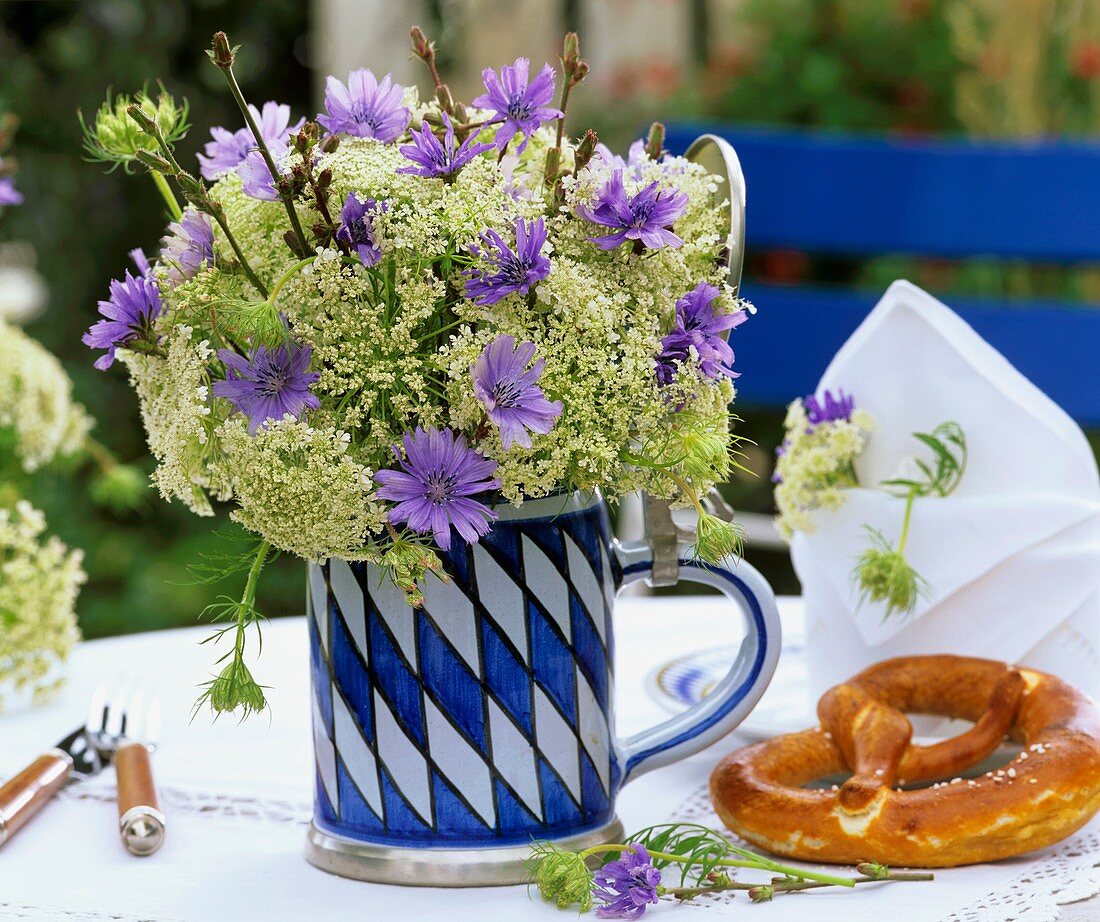 Chicory flowers & cow parsley in Bavarian beer mug, pretzel