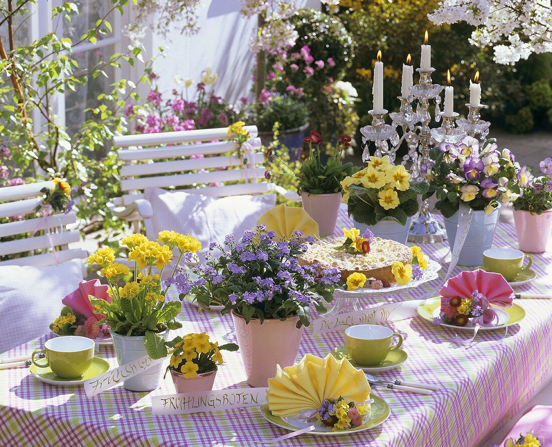 Bunter Frühlingshaft gedeckter Tisch auf der Terrasse