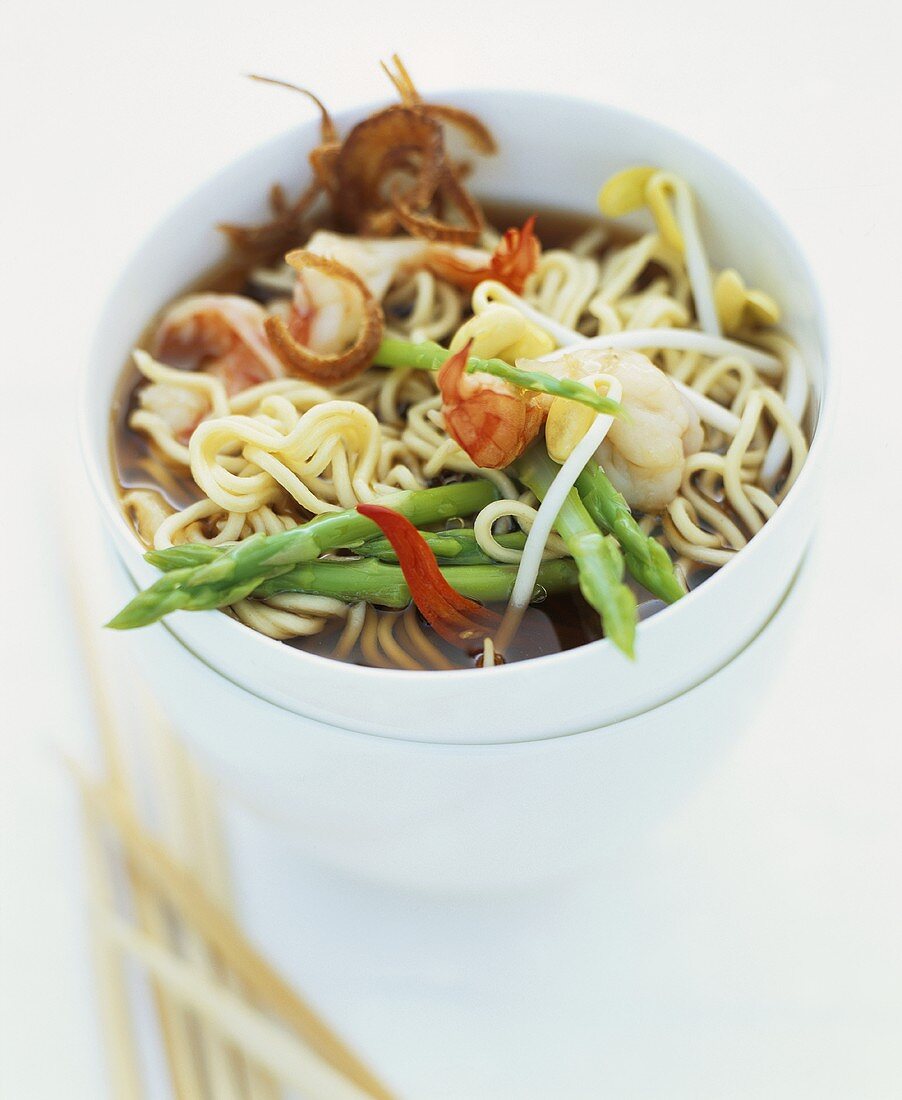 Noodle soup with green asparagus, king prawns and sprouts