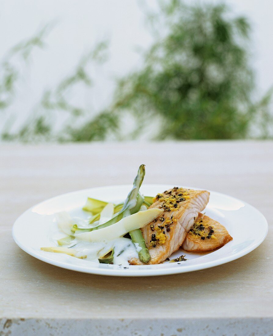 Fried salmon with lemon on two kinds of asparagus in cream