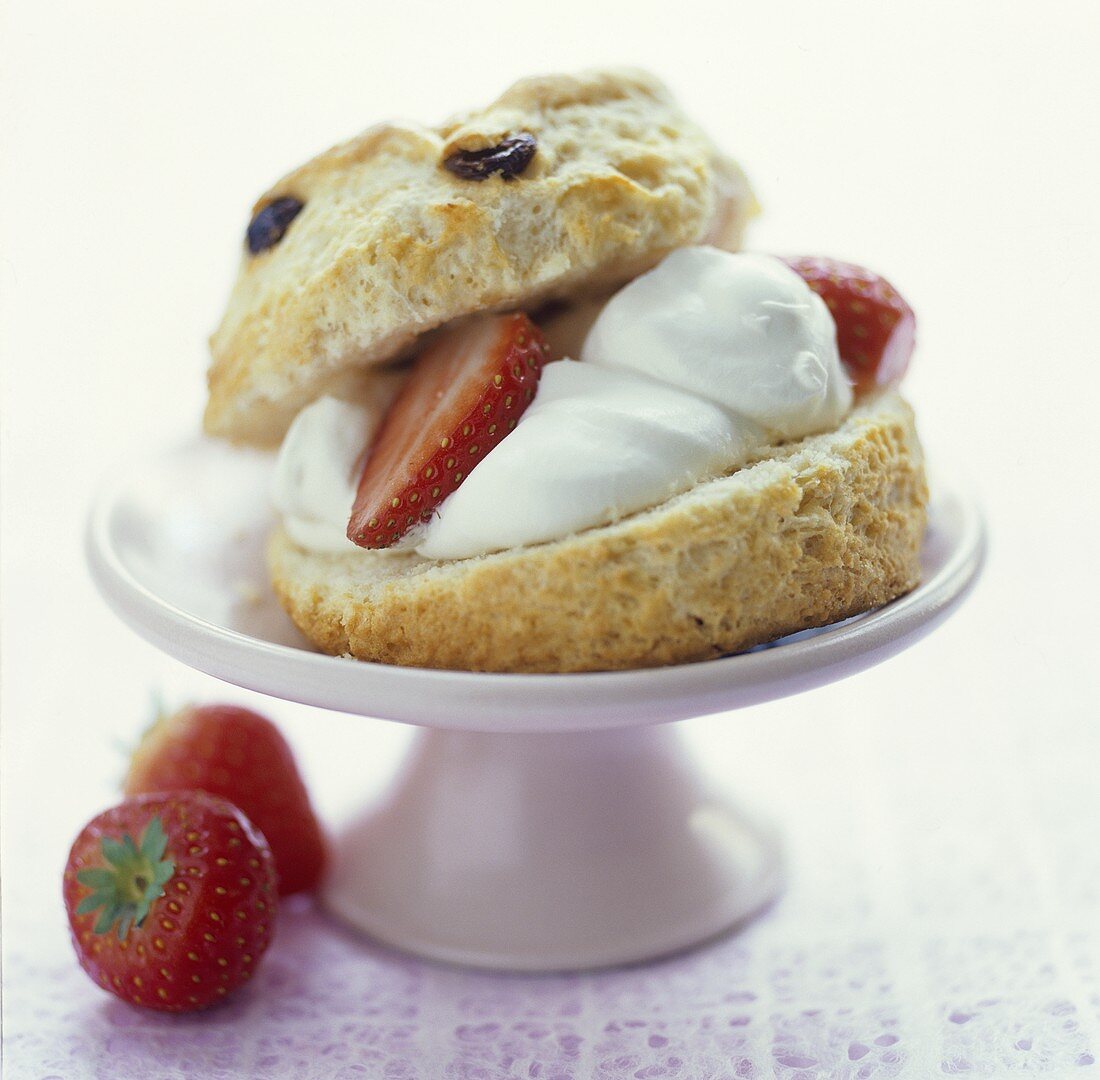 A scone filled with cream and fresh strawberries