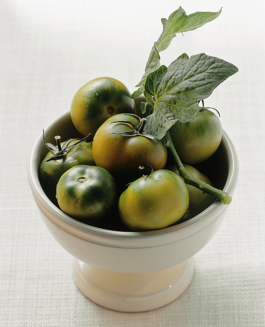 Green tomatoes in a pedestal bowl