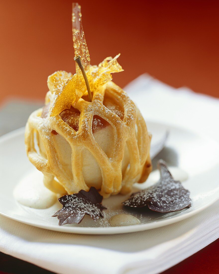 Apple dumpling (baked apple in pastry) with chocolate leaves