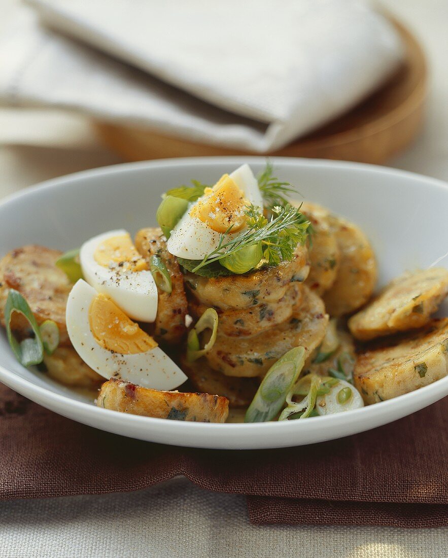 Bacon dumpling salad with spring onions and egg