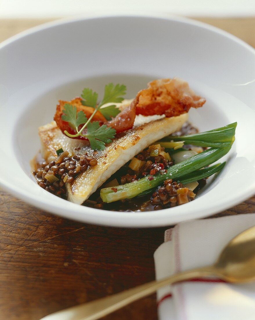 Fried zander with bacon on lentils