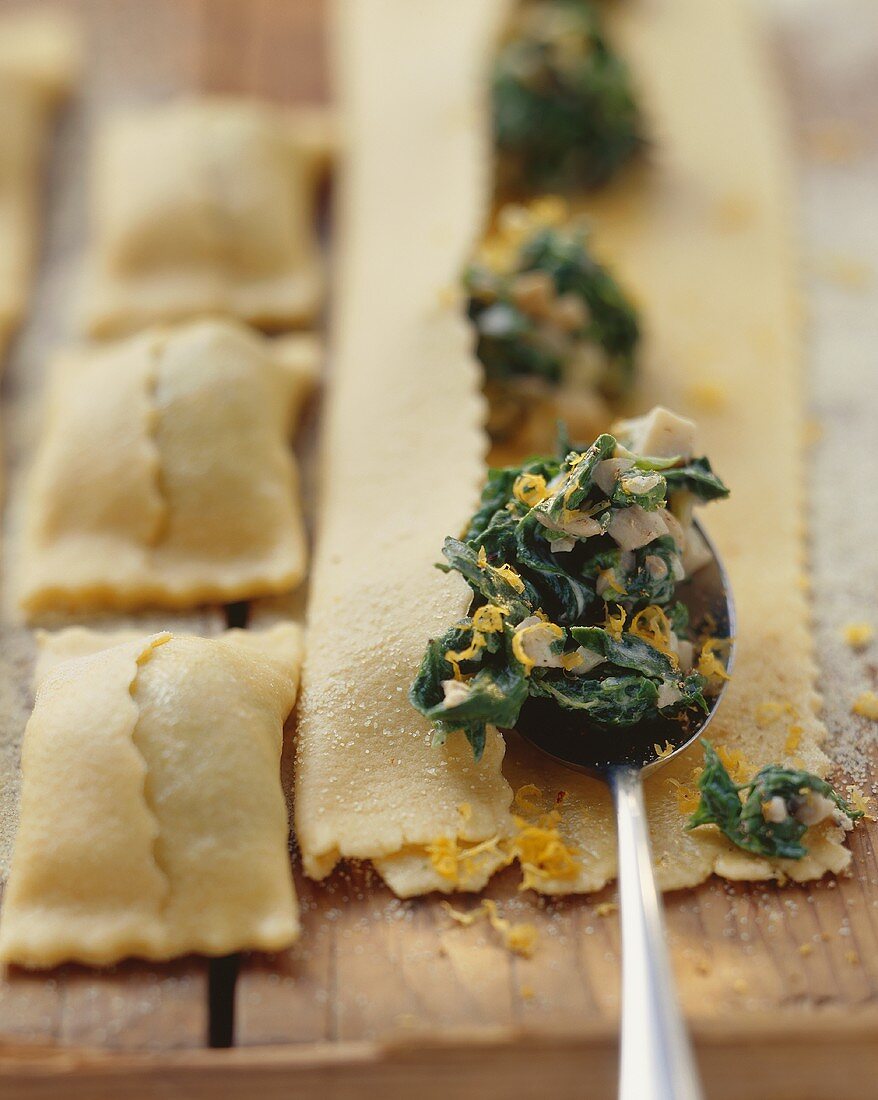 Filling pasta squares with spinach and ceps