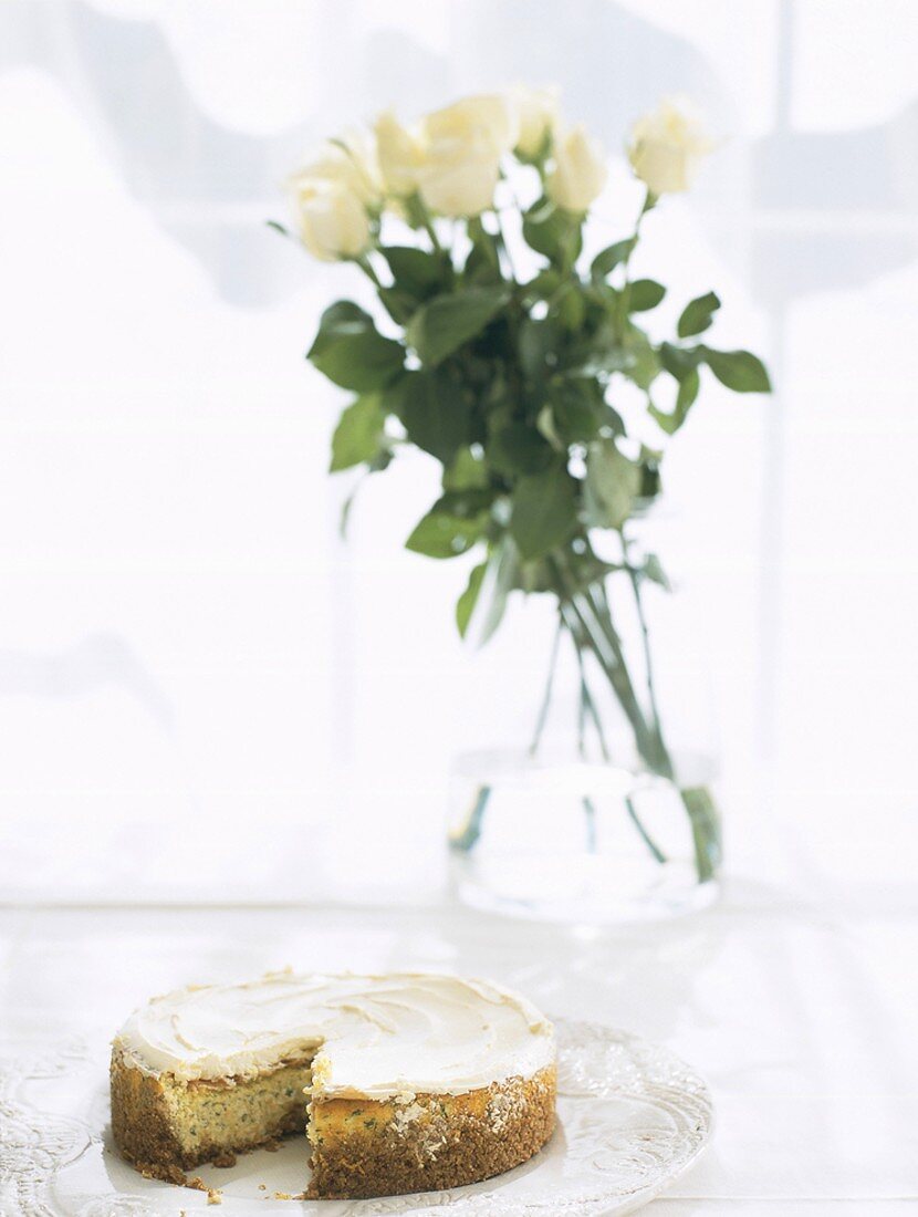 Sliced nut cake with a bunch of white roses