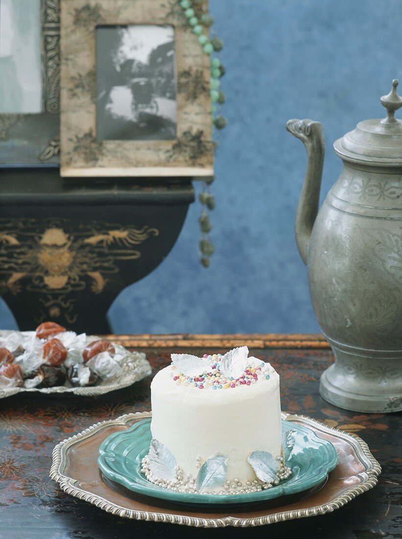 A mini cake decorated with sugar pearls