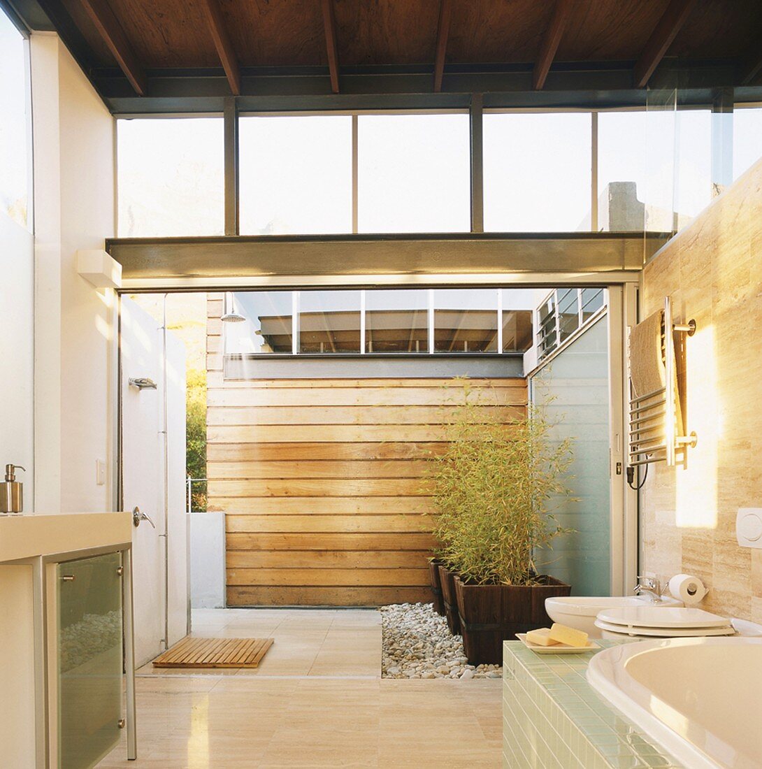 Freundliches Badezimmer mit Holzbalkendecke und Zugang zum Atrium des modernen Wohnhauses