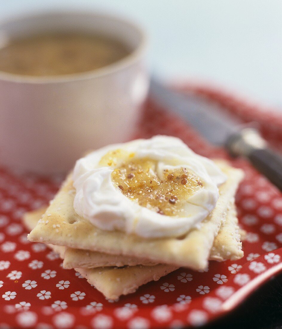 Ein Stapel Salz-Cracker mit Frischkäse und Senfsauce