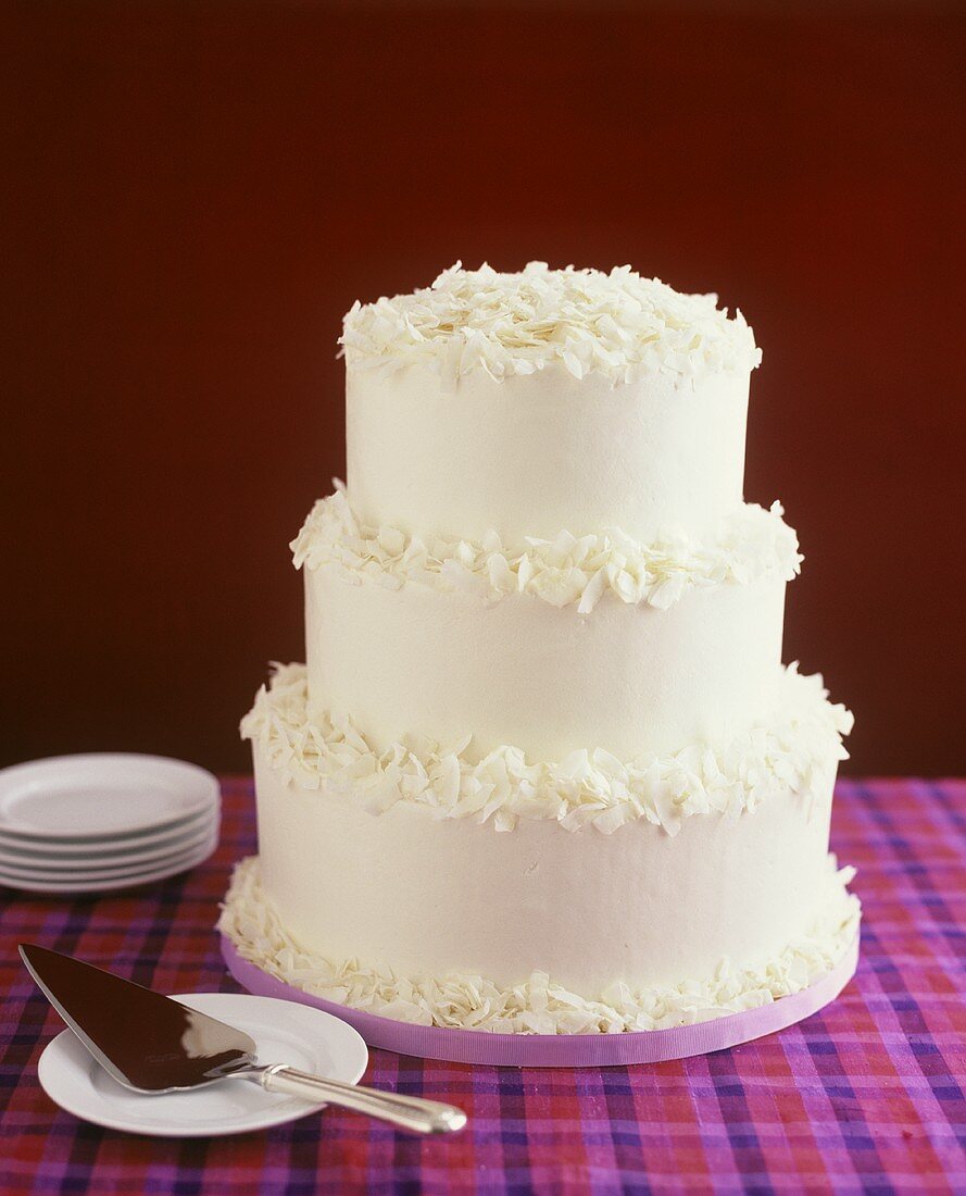 Three-tiered white coconut wedding cake
