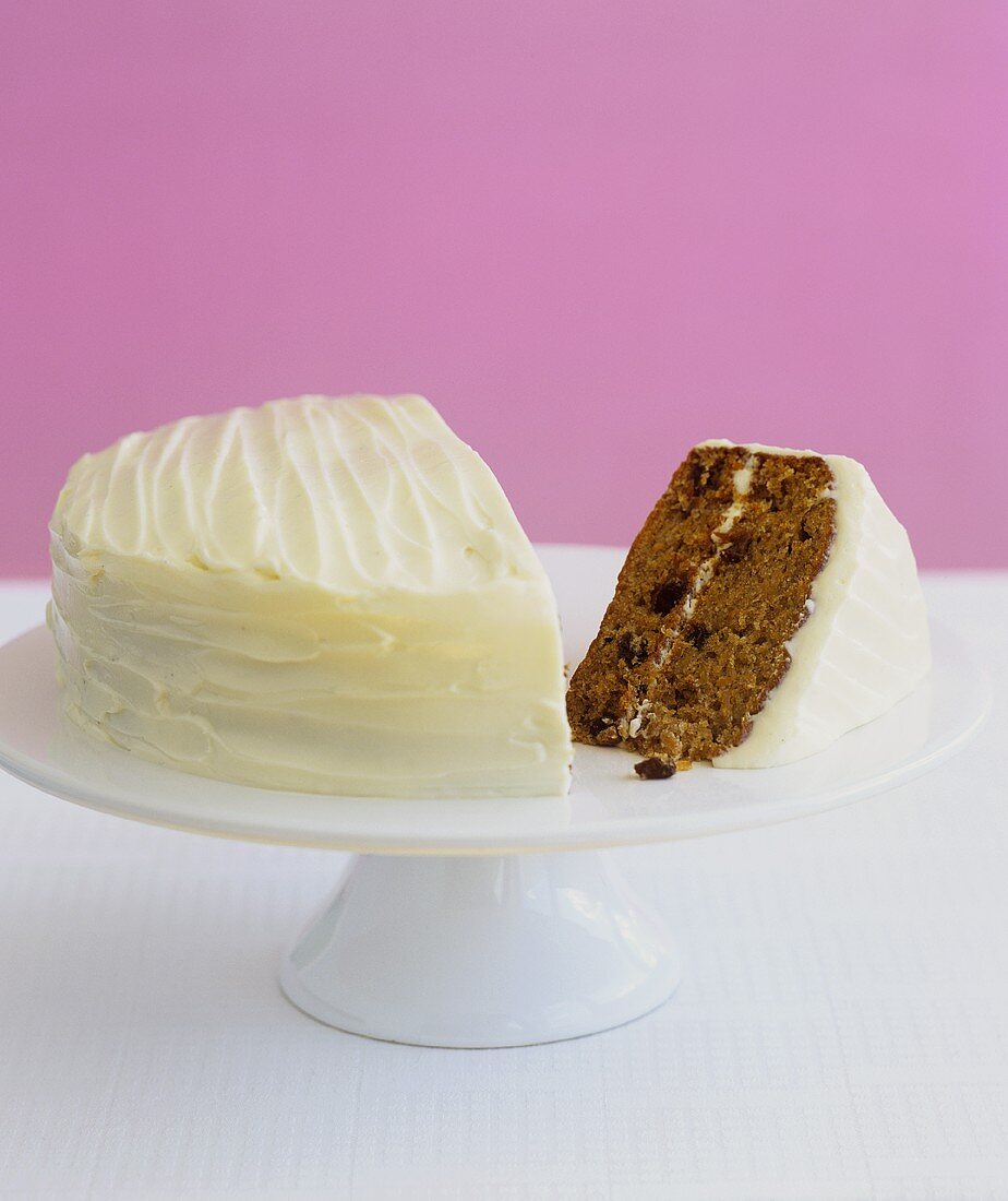 Carrot cake, a piece cut, on cake stand