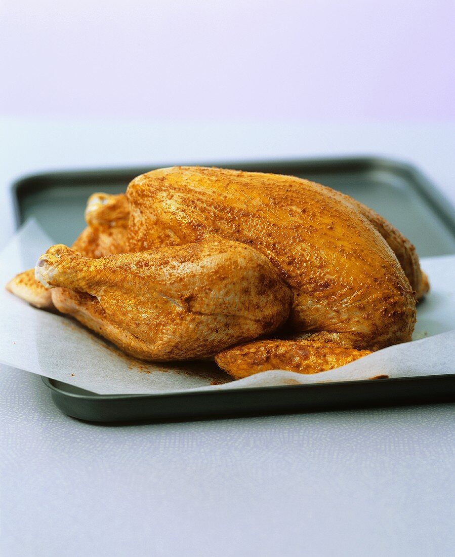 Raw marinated chicken on baking tray