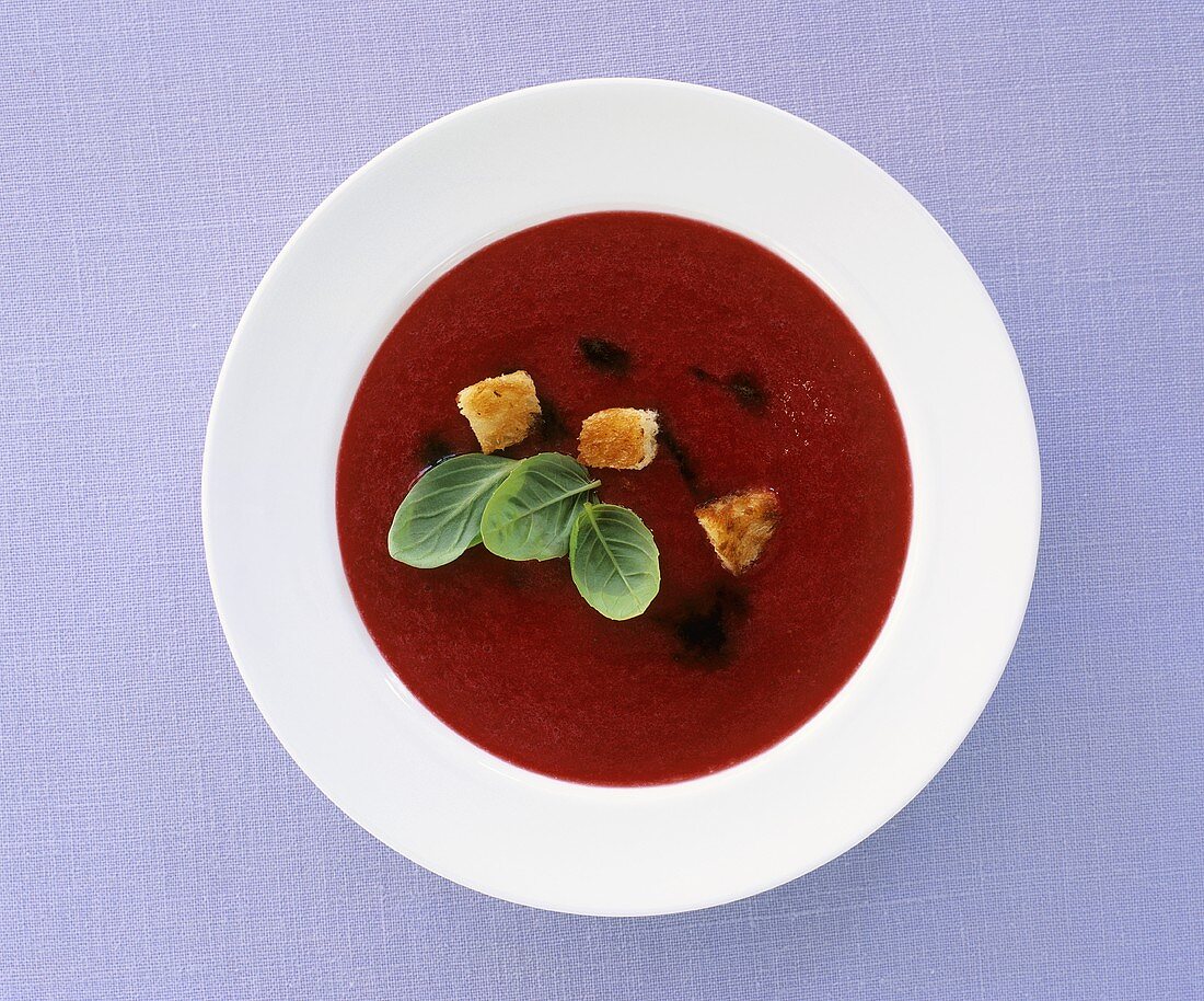 Red berry soup with croutons, balsamic vinegar & basil leaves