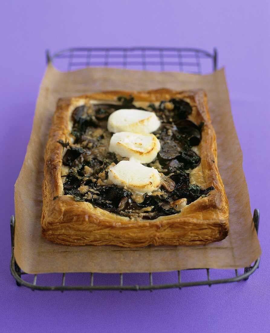 Mushroom & goat's cheese tart on a rack with baking parchment