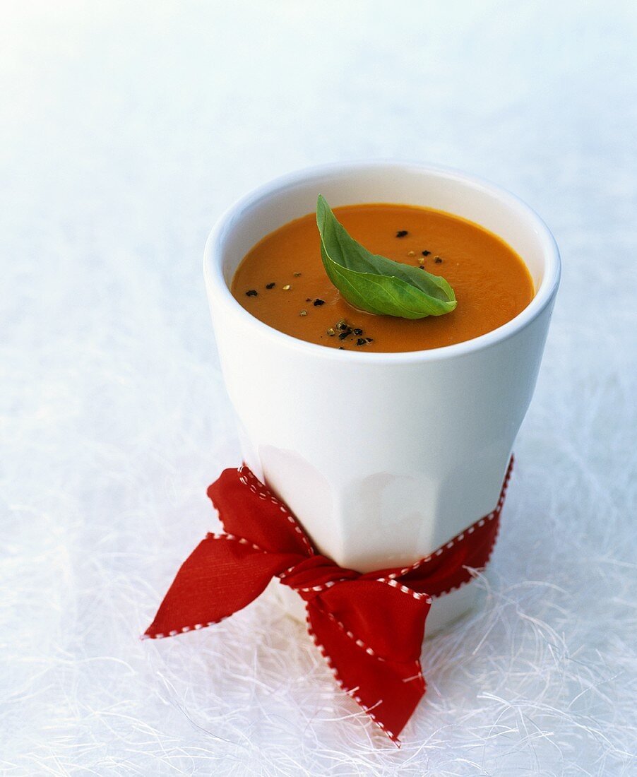 Cream of tomato soup in beaker with red bow