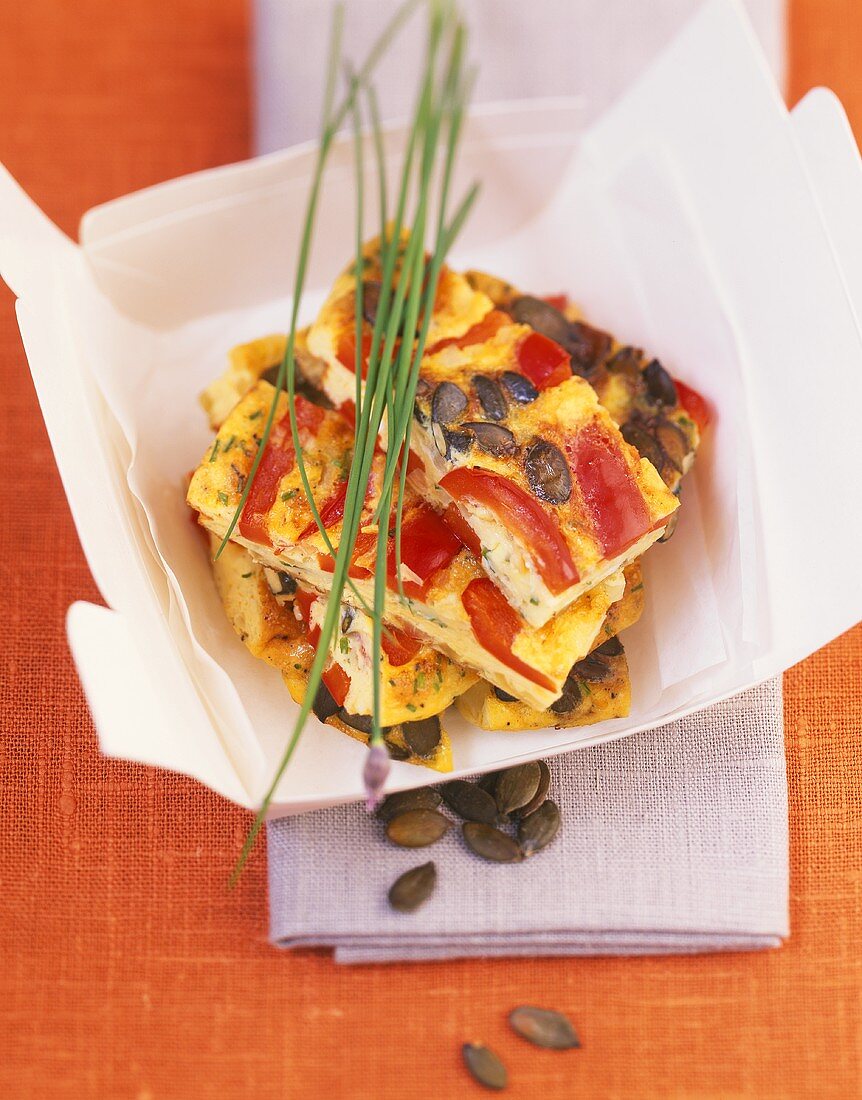 Tortilla with red pepper and pumpkin seeds in cardboard box