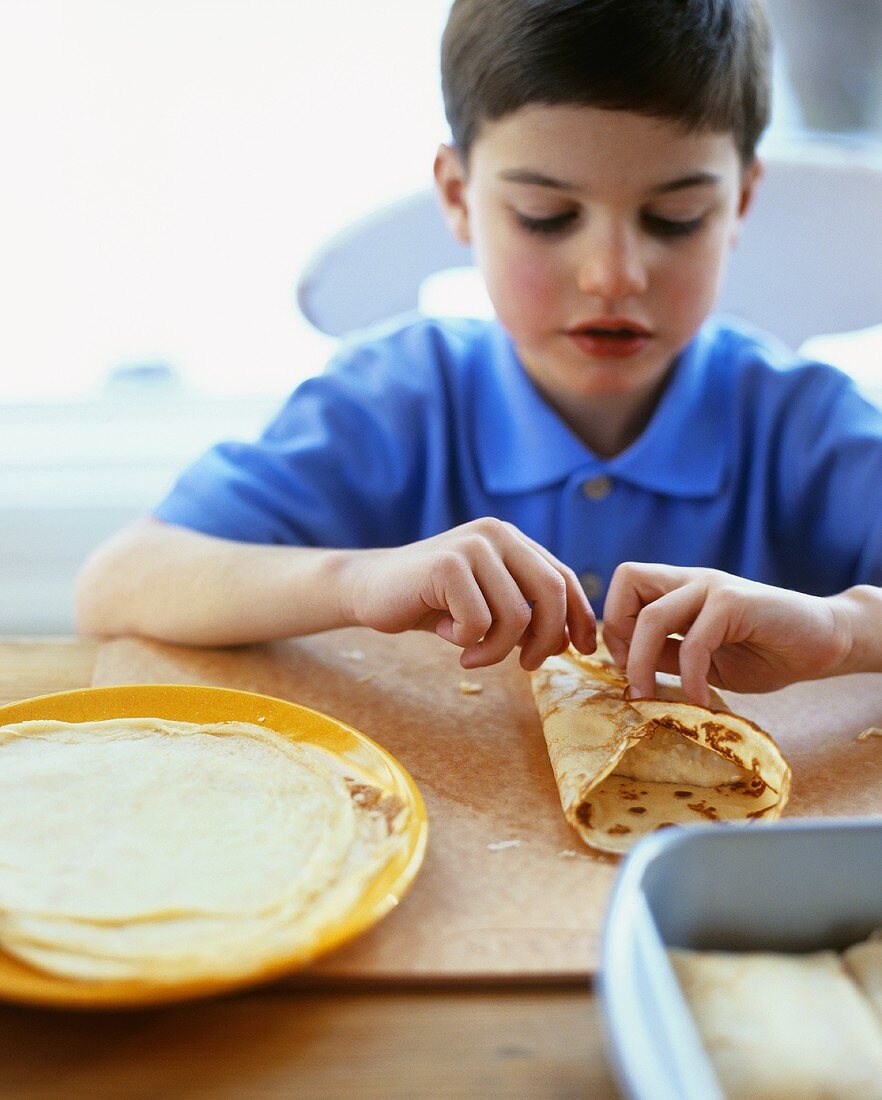 Boy filling pancakes